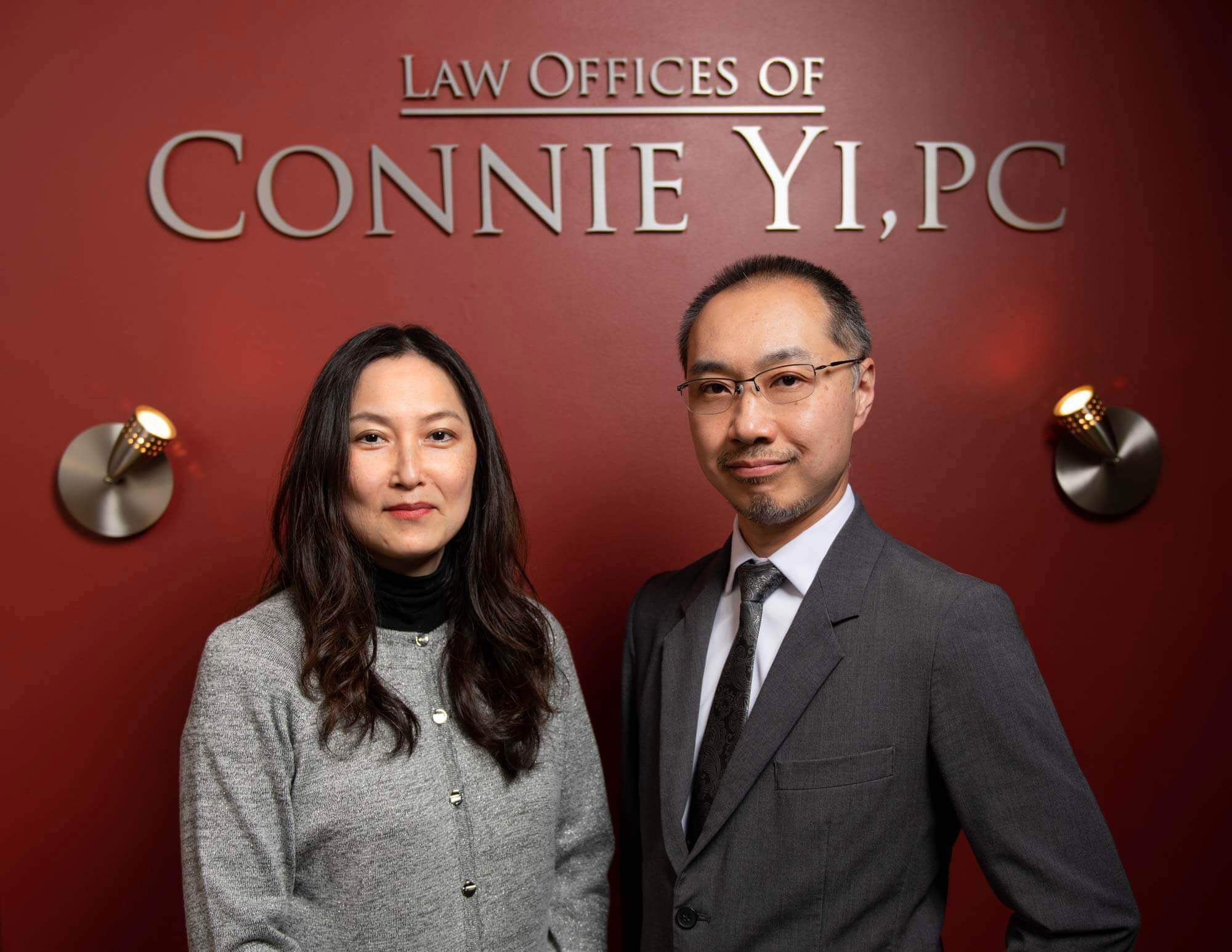 Attorneys Connie Yi and Bobby Y. Lydon-Lam under the interior office sign for the firm